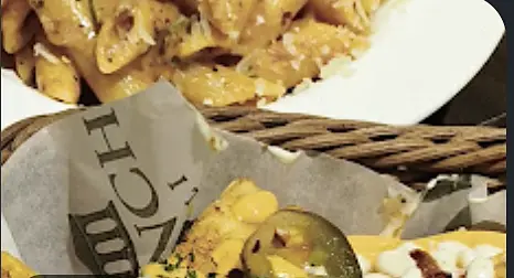 Cheese-loaded fries in a basket lined with Bench Deli paper