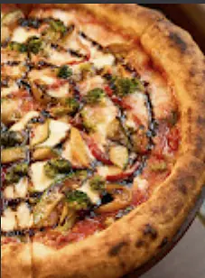 A pizza fresh from the oven, finished with basil pesto